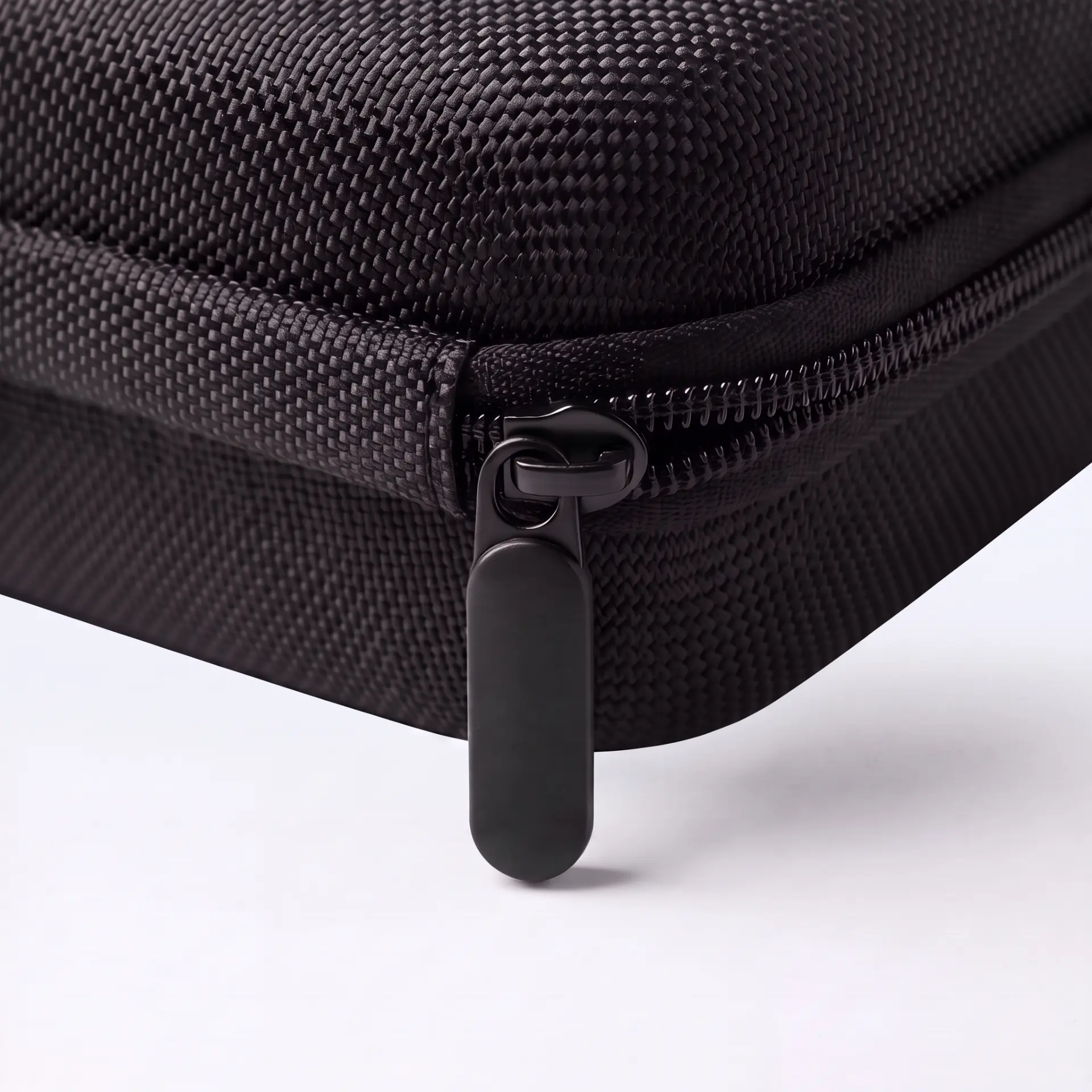 Close-up of the case's black zip pull and woven shell